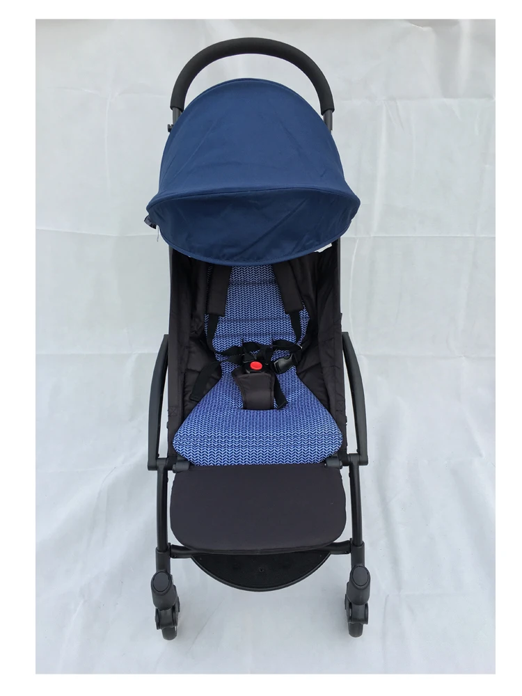 Un cochecito con capota azul y asiento azul. El cochecito parece tener un diseño compacto y plegable, que suele ser conveniente para viajar o guardarlo.