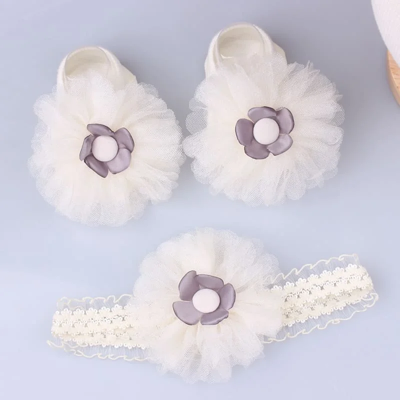 Un par de zapatos de bebé blancos con flores moradas en ellos
