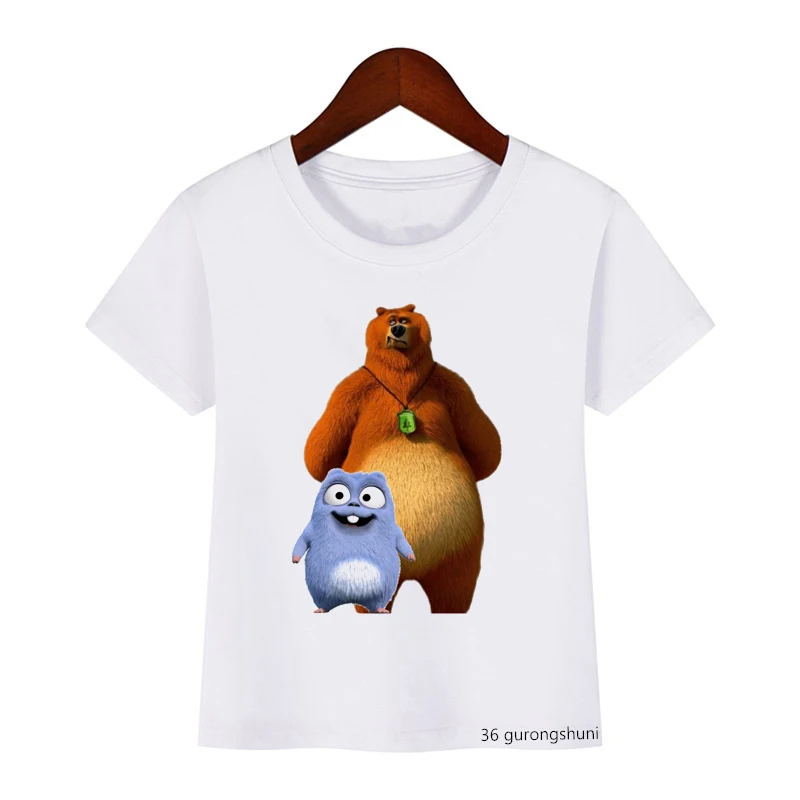 Una camiseta blanca con un estampado gráfico. La impresión presenta dos personajes animados: un gran oso pardo y una criatura azul más pequeña que parece ser un monstruo o una criatura con una expresión amistosa. El oso está erguido y tiene una etiqueta verde en la oreja.