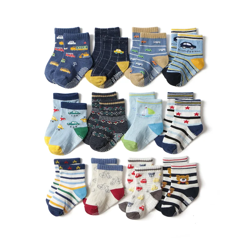 Una colección de calcetines para niños. Vienen en varios diseños y patrones, que incluyen rayas, lunares e imágenes de automóviles y otros vehículos. Los calcetines se muestran en un patrón de cuadrícula, lo que muestra la variedad de estilos disponibles.