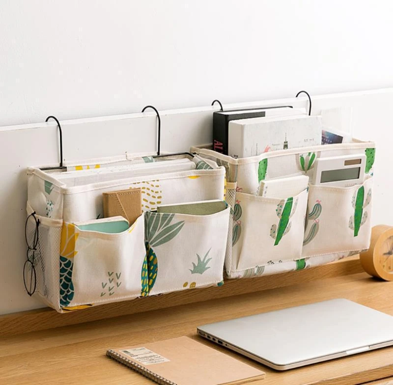 Una estantería de pared con varias cestas de almacenamiento. Las cestas tienen un patrón colorido con detalles en verde y amarillo, y parecen estar hechas de un material de tela. El estante está montado en una pared blanca y hay una computadora portátil en un escritorio debajo del estante.