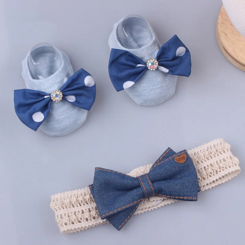 Un par de zapatos de bebé con arcos azules y una pajarita de mezclilla