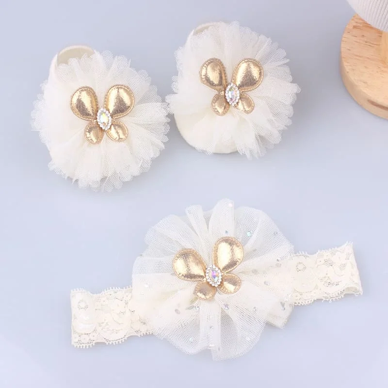 Un par de zapatos de bebé blancos con flores doradas y cristales