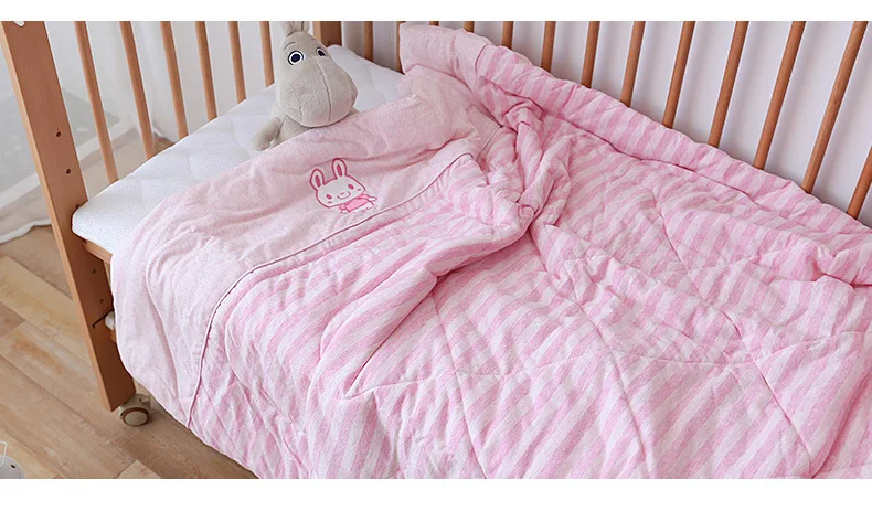 Una cama rosa con un animal de peluche