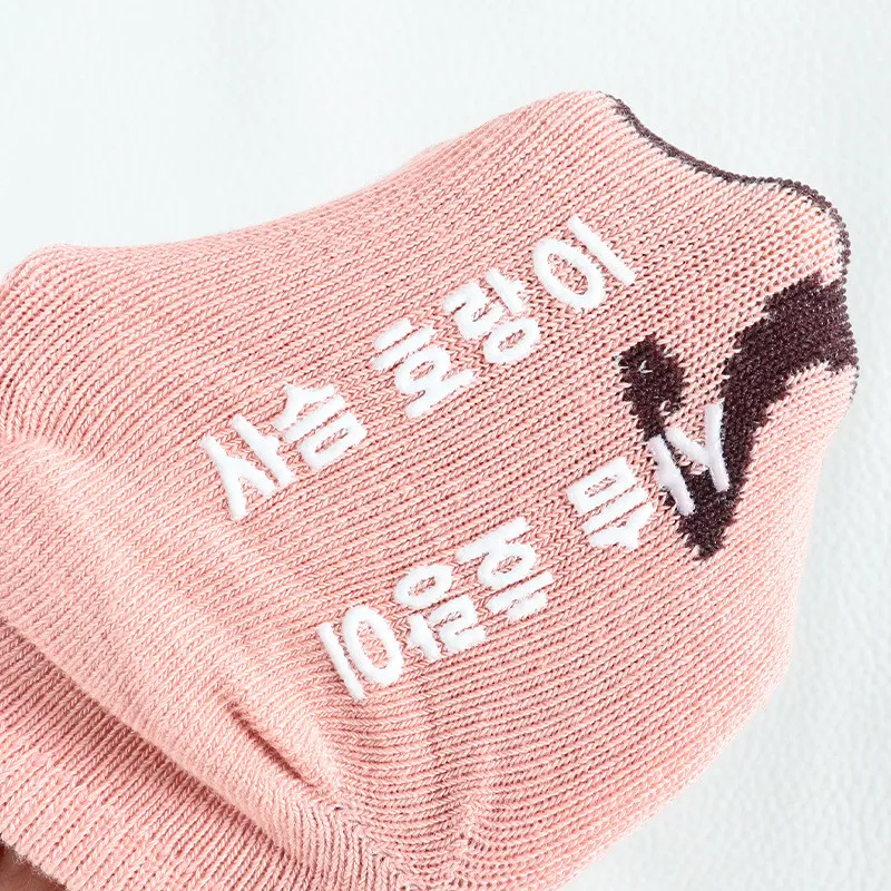 Un calcetín rosa con texto. El texto parece estar en coreano y dice 아이오브오 10일, que se traduce como AIOBO 10 días en inglés.