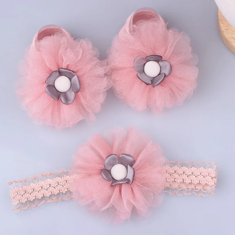 Un par de zapatos de bebé rosa con flores blancas en ellos