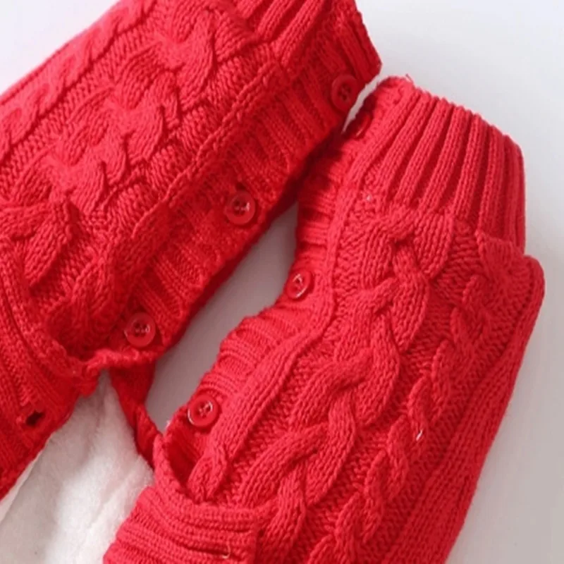 Un par de guantes de punto rojos. Tienen puños acanalados y parecen estar diseñados con un patrón que incluye trenzas o giros, que es un estilo común en prendas de punto.