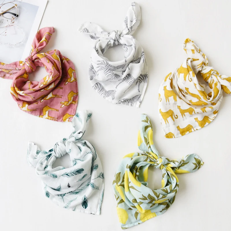 Una colección de seis pañuelos con diferentes estampados y colores. Cada pañuelo está atado en un lazo y están ordenados cuidadosamente sobre una superficie blanca. Los patrones incluyen estampados florales, animales y diseños abstractos.