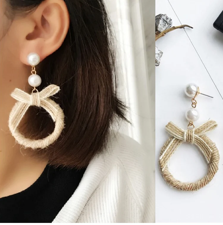 Una mujer con un suéter blanco y aretes
