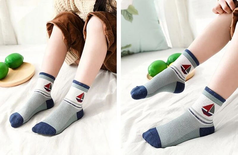 Una persona que lleva un par de calcetines con temática náutica. Los calcetines tienen un diseño de ancla roja en el costado y se combinan con una falda marrón.