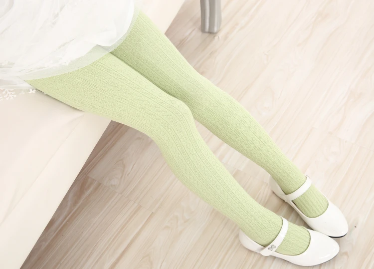 Una mujer con medias verdes y zapatos blancos