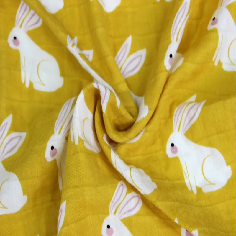Tela con estampado de conejos blancos sobre fondo amarillo. Los conejos están representados de forma sencilla y estilizada, con algunas variaciones en sus poses.