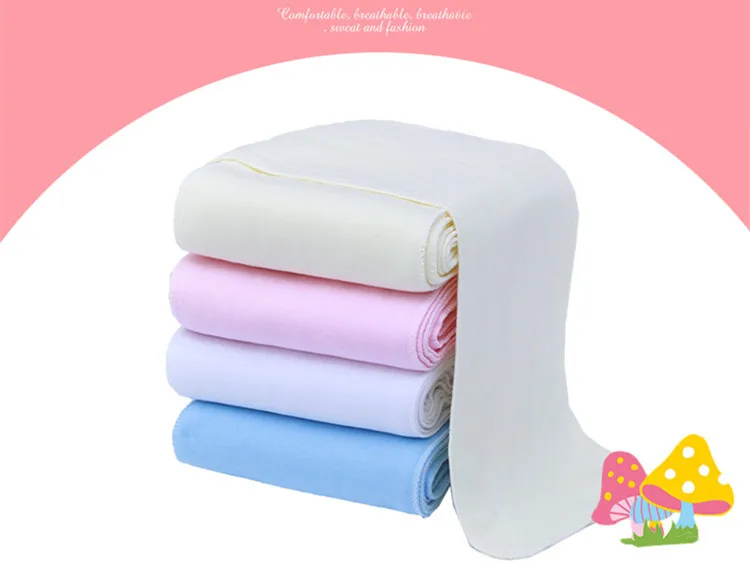 Una pila de toallas dobladas de varios colores, incluidos blanco, rosa y azul. Las toallas parecen estar cuidadosamente enrolladas y colocadas sobre una superficie con un fondo rosa.