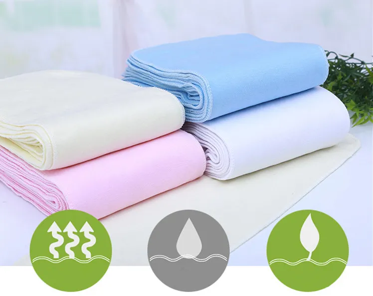 Una pila de toallas dobladas de tres colores diferentes: blanco, rosa y azul. Cada toalla parece estar cuidadosamente doblada y apilada una encima de la otra.