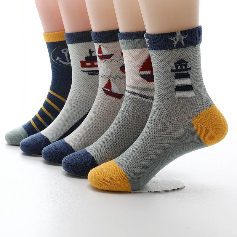 Una colección de calcetines con varios diseños. Cada calcetín tiene un estampado diferente, que incluye temas náuticos como anclas, barcos y faros. Los calcetines se exhiben en un soporte y parecen ser de un tejido de alta calidad, posiblemente pensado para brindar calidez y comodidad.