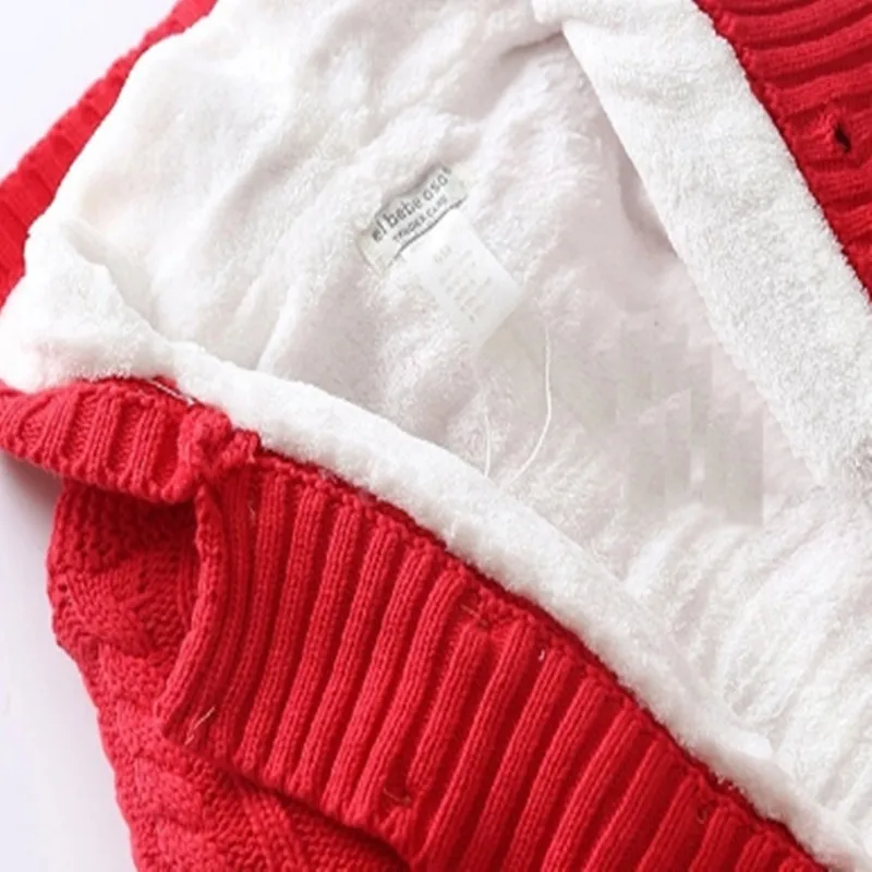 Un primer plano de una prenda con una combinación de colores rojo y blanco. La prenda parece ser una prenda de punto, posiblemente un suéter o una bufanda, con textura acanalada.