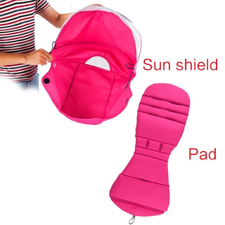 Un protector solar rosa y una almohadilla rosa. El parasol parece ser una cubierta protectora que se puede utilizar para proteger a un bebé o a un niño del sol mientras está en un cochecito o portabebés.