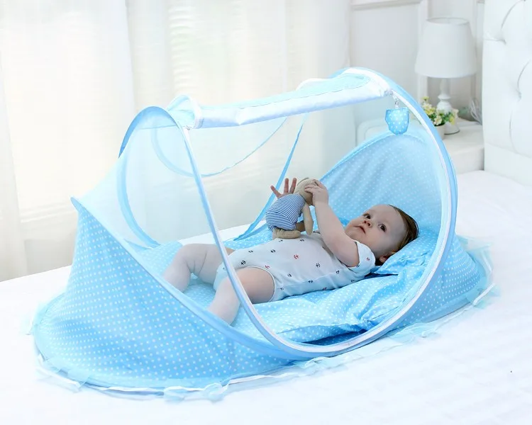 Un bebé en una cuna con una manta azul y un juguete azul