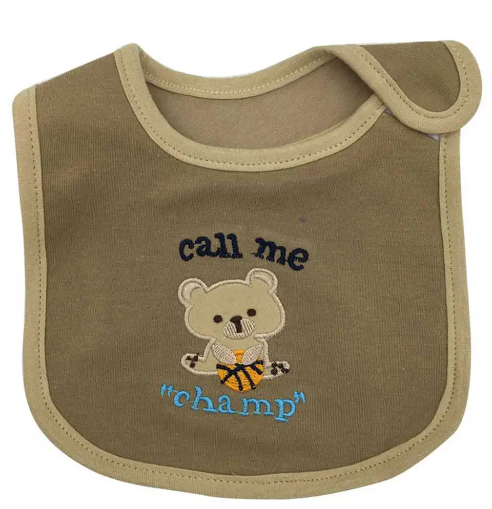 Un babero con un lindo diseño. Presenta un osito de peluche estilo dibujos animados que lleva una camiseta de baloncesto con la palabra CHAMP. Encima del oso, hay una frase que dice LLAMAME 'CAMPEÓN'.