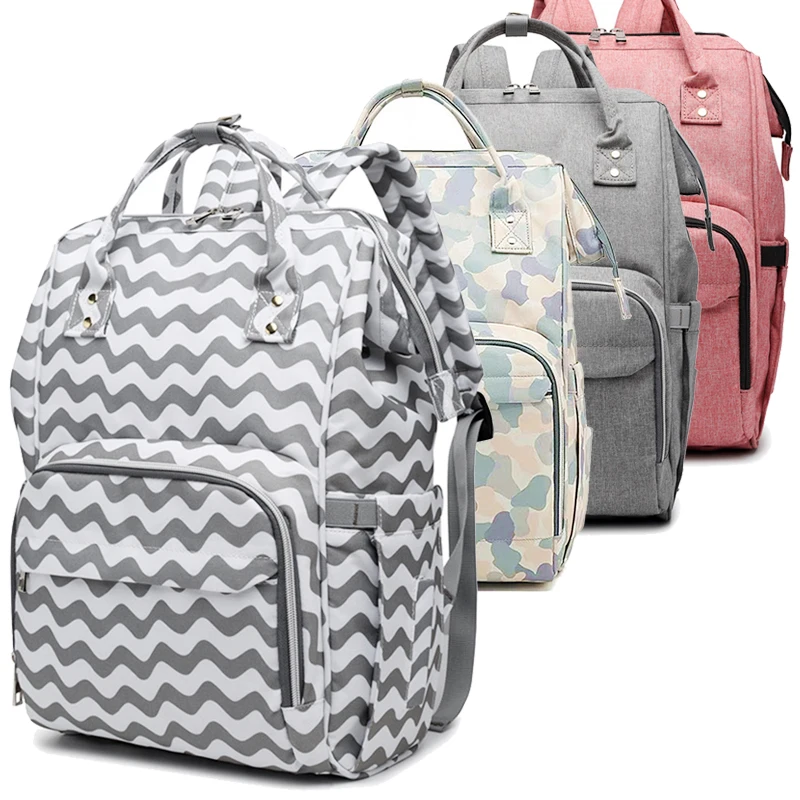 Una colección de mochilas. Son cuatro mochilas en total, cada una con un diseño y color diferente. Las mochilas parecen estar hechas de un material de tela y tienen varias características como cremalleras, bolsillos y correas.