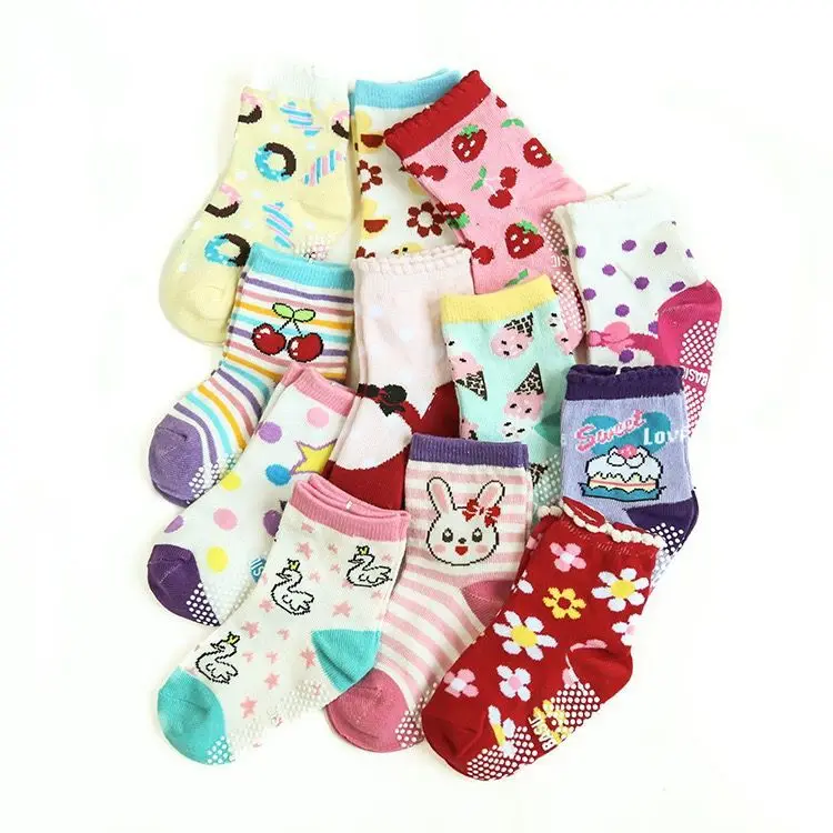 Una colección de calcetines infantiles de colores. Presentan varios patrones y diseños, incluidos estampados de animales, lunares y otros motivos divertidos. Los calcetines están dispuestos de manera que se superpongan entre sí, creando una exhibición vibrante y alegre.