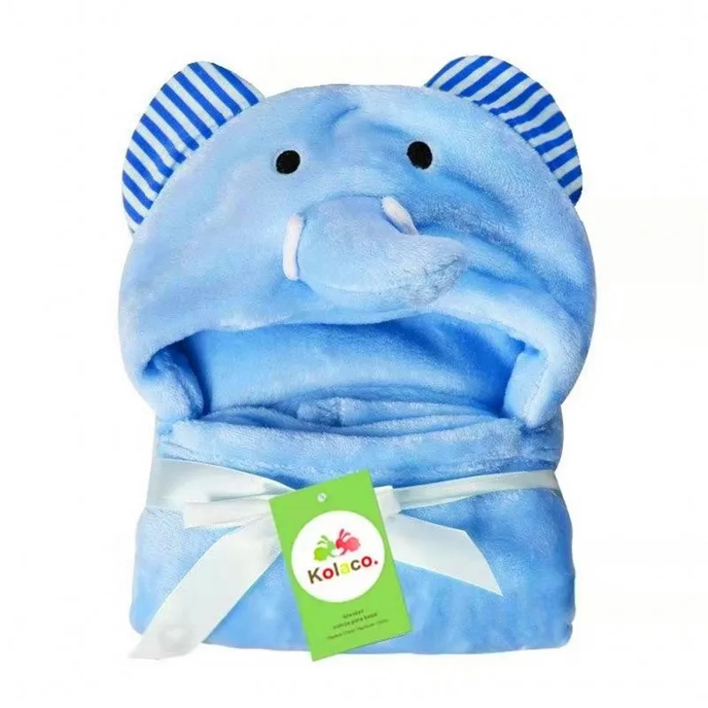 Un peluche que se parece a un elefante. Tiene el cuerpo azul con el vientre blanco y sus orejas tienen rayas azules y blancas. El juguete tiene una cara linda con ojos negros y un baúl pequeño. Hay una etiqueta verde adherida al juguete con el texto Kolala.