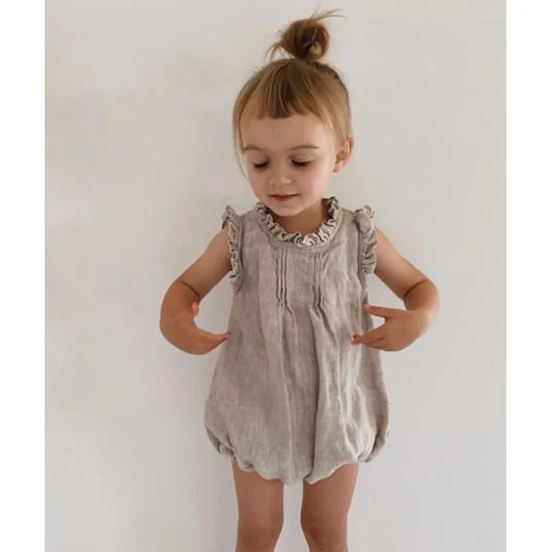 Vestido de lino sin mangas para niña en color beige claro, con escote redondeado y tejido ligero