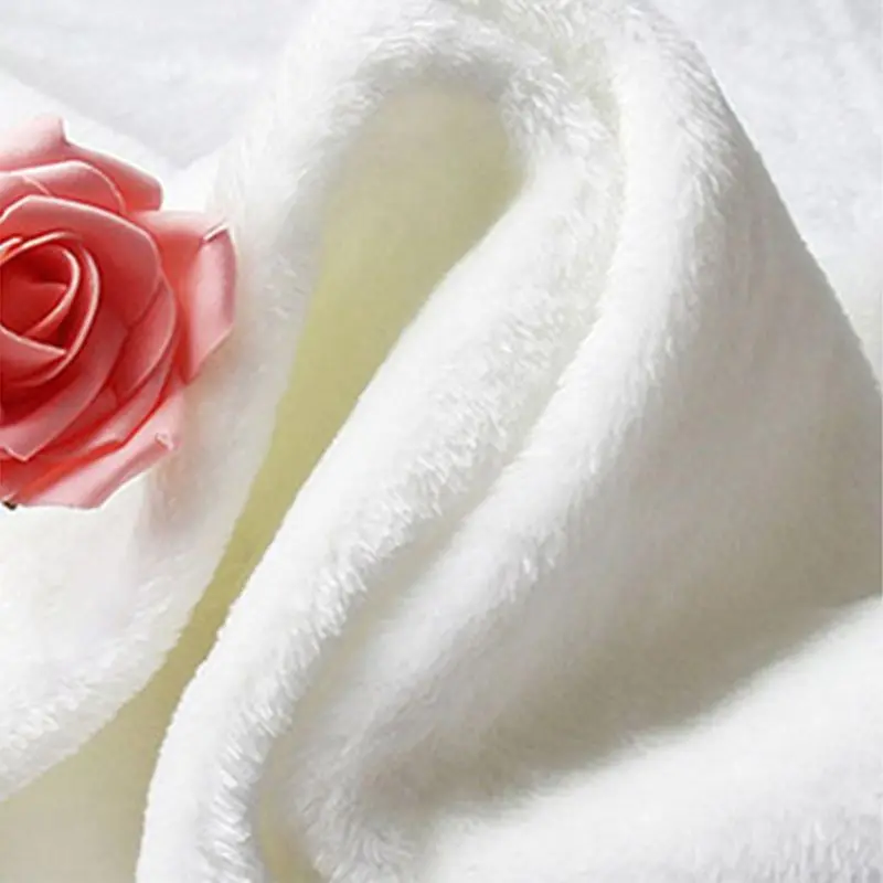 Un primer plano de una rosa con los pétalos parcialmente desplegados, dejando al descubierto las capas internas. La rosa parece ser rosada o de un tono claro de rojo.
