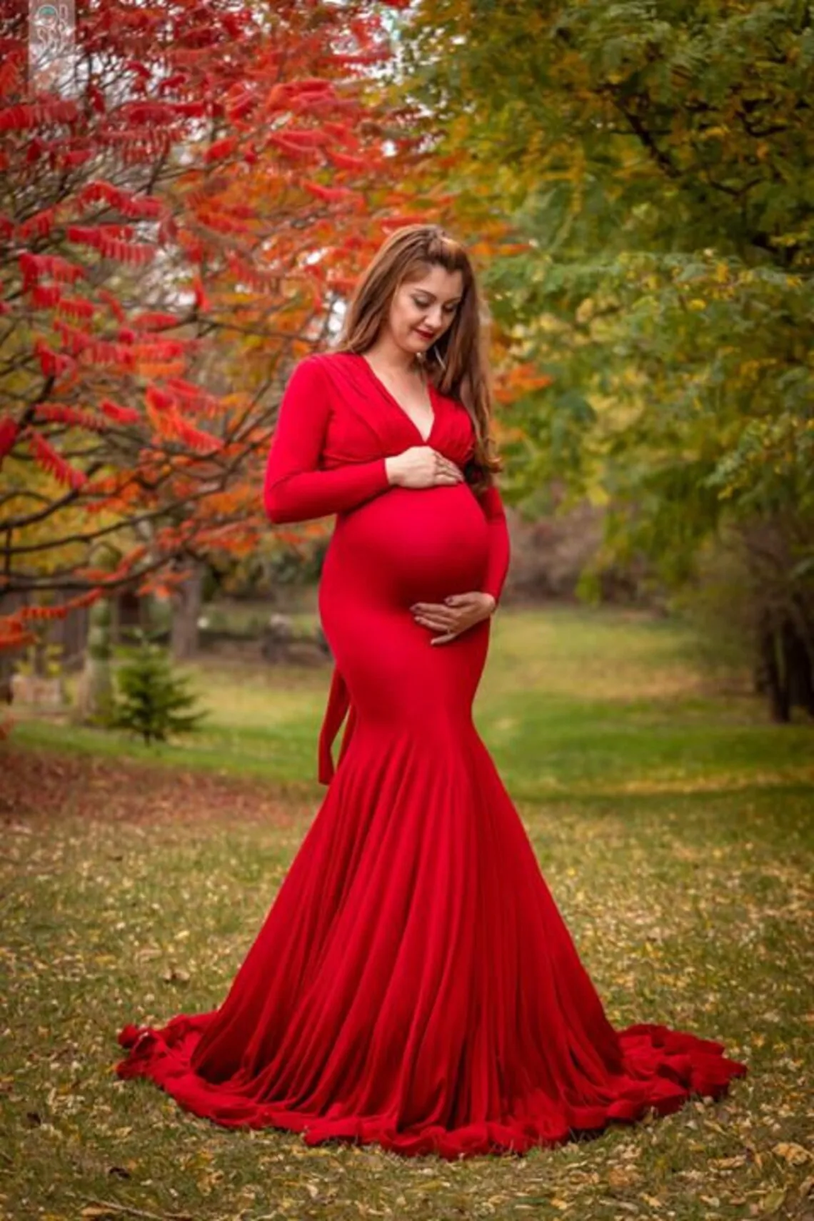 Una mujer con un vestido rojo y sosteniendo su vientre
