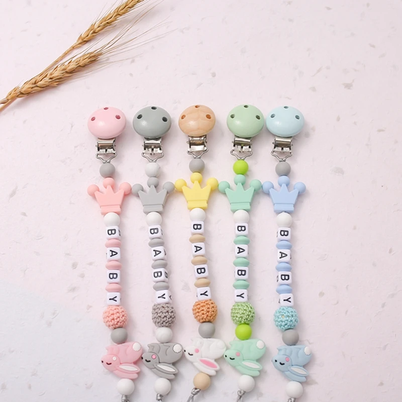 Una fila de chupetes para bebés con diferentes colores y diseños.
