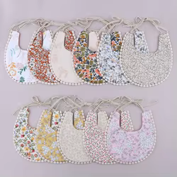 Pañuelo babero doble cara con borlas y estampado floral para bebé