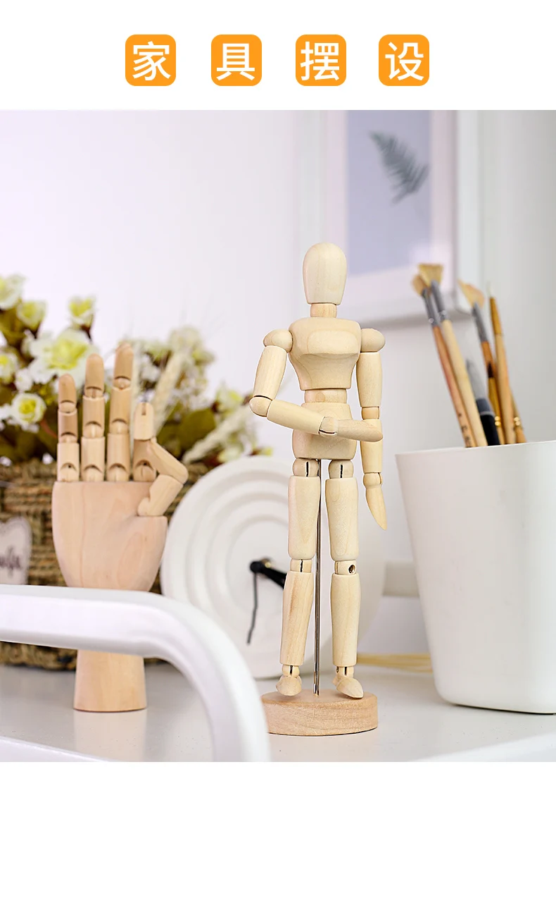 Un maniquí de madera está de pie sobre una mesa junto a un jarrón de flores