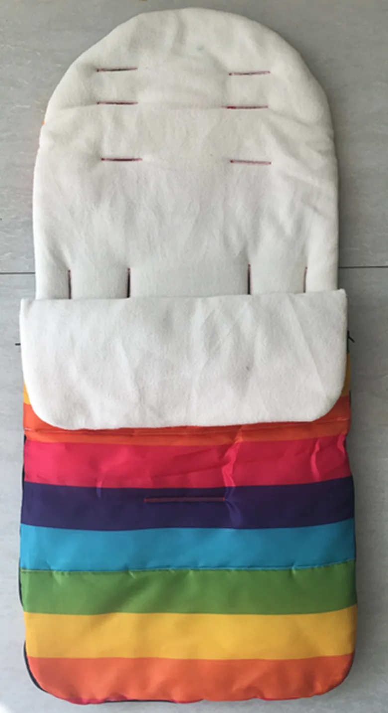 Un artículo de tela a rayas de colores que parece ser un bolso o una bolsita. Tiene una sección superior blanca con cremallera y la sección inferior está dividida en franjas horizontales de varios colores. Los colores incluyen tonos de rosa, morado, azul, verde, amarillo y naranja.