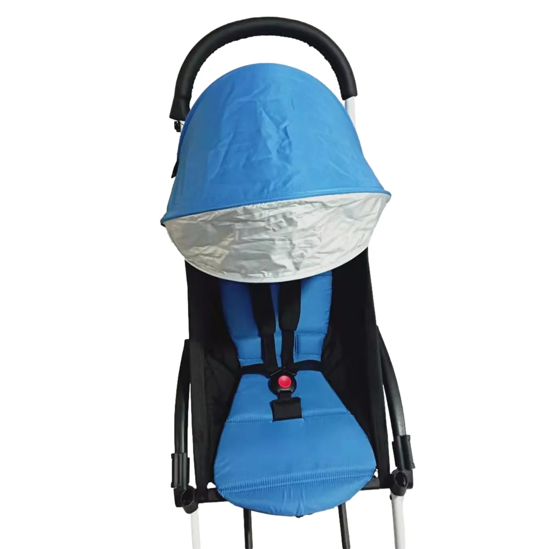 Un asiento de coche para niños. Parece ser un asiento de seguridad orientado hacia atrás, diseñado para bebés y niños pequeños. El asiento tiene una funda azul y un parasol plateado que se puede bajar para proteger al niño del sol.