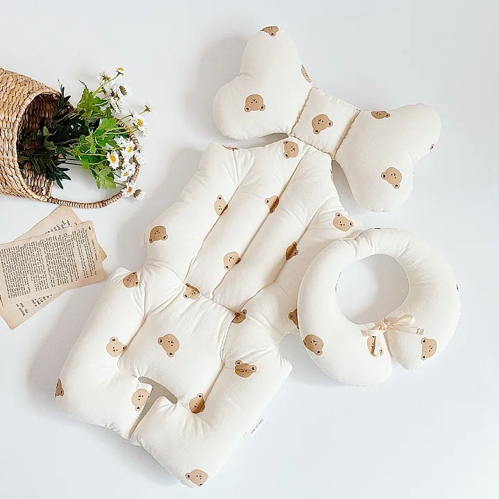 Una almohada blanca con manchas marrones y un arco marrón sobre ella