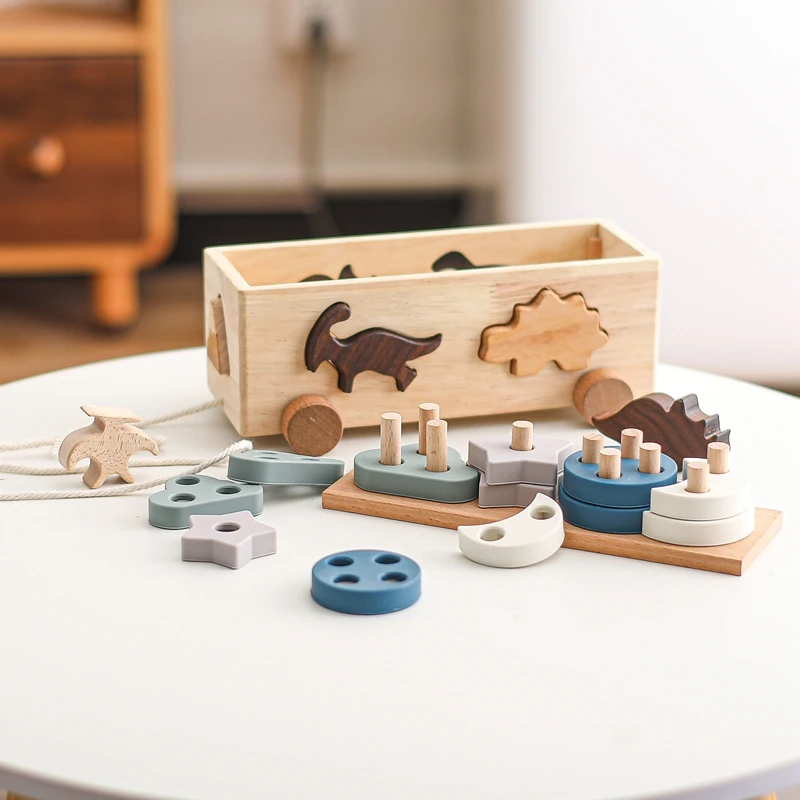 Una caja de madera con varios juguetes de madera y una mesa blanca