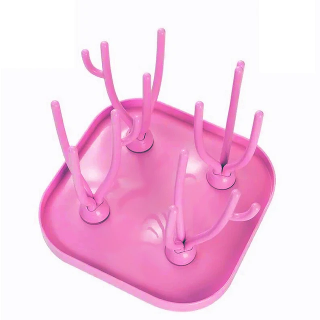 Una bandeja de plástico rosa con múltiples orificios diseñada para sostener los cepillos de dientes en posición vertical. Es probable que la bandeja se use para mantener los cepillos de dientes organizados y secos después de su uso.