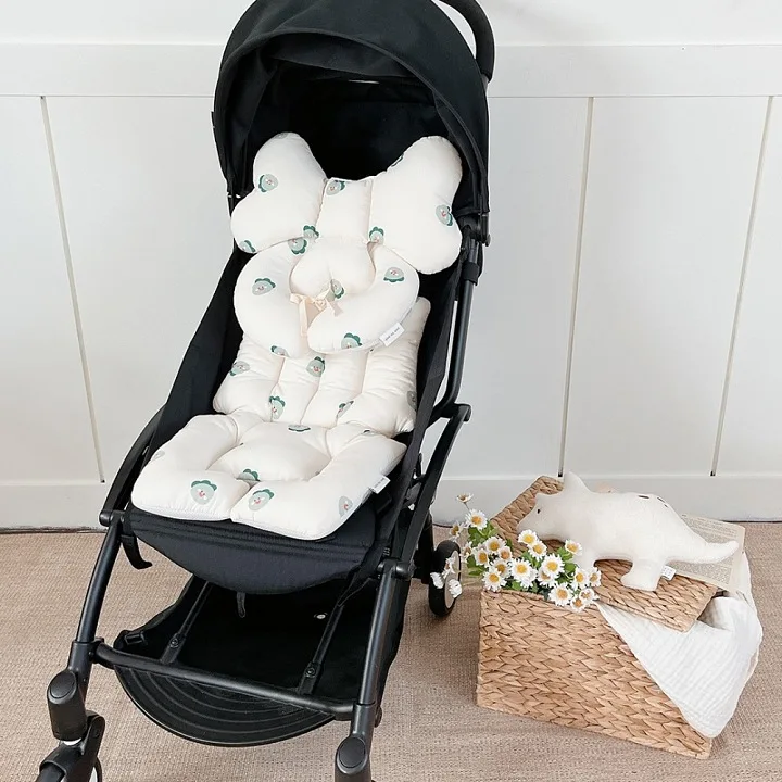 Un cochecito para bebés con una canasta de flores al lado