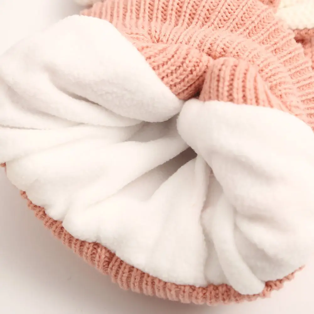 Un sombrero de punto rosa y blanco