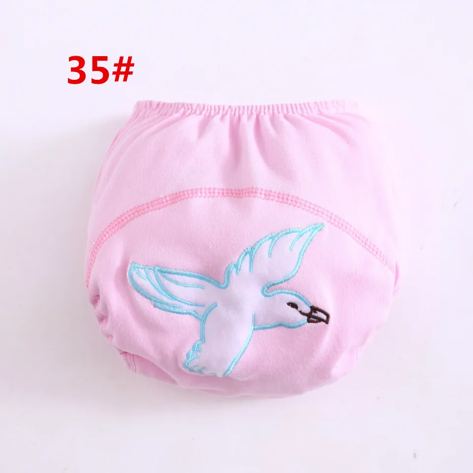 Un par de calzoncillos de color rosa con un pájaro blanco bordado en la parte delantera. La ropa interior parece ser para un niño o un adulto pequeño, dado el tamaño y el estilo.