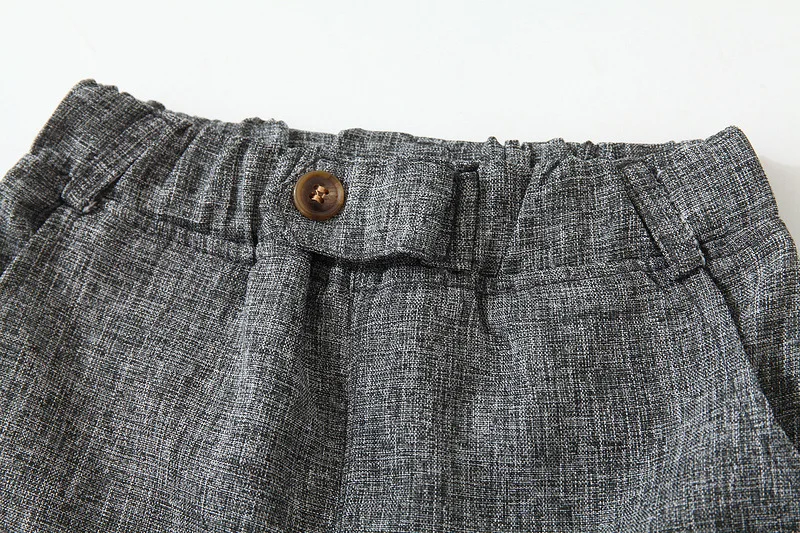 Un par de pantalones cortos grises con un botón en el costado