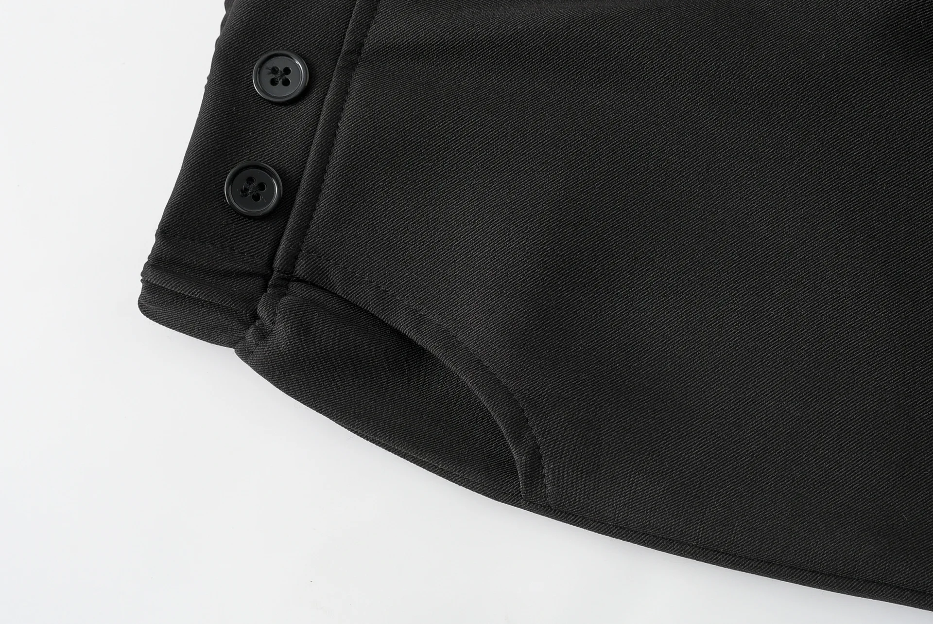 Un par negro de pantalones con botones en el costado