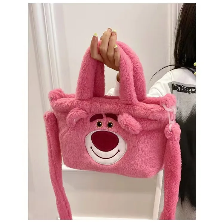 Una mujer sosteniendo un bolso rosa con una cara