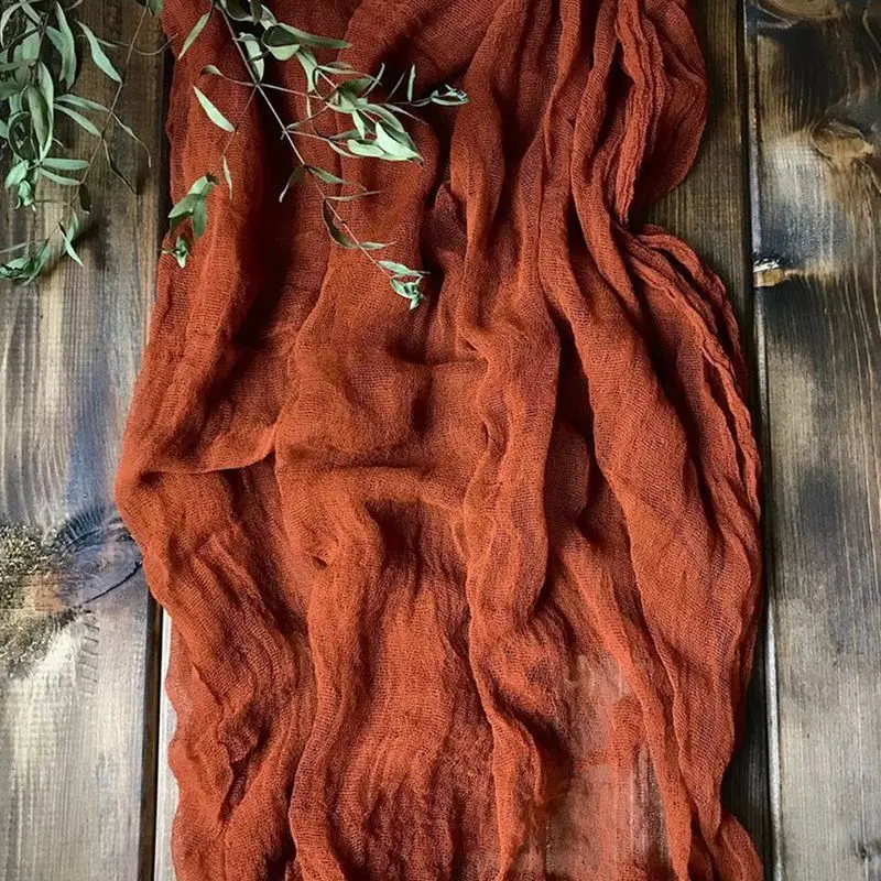Una bufanda roja se cubre sobre una mesa de madera
