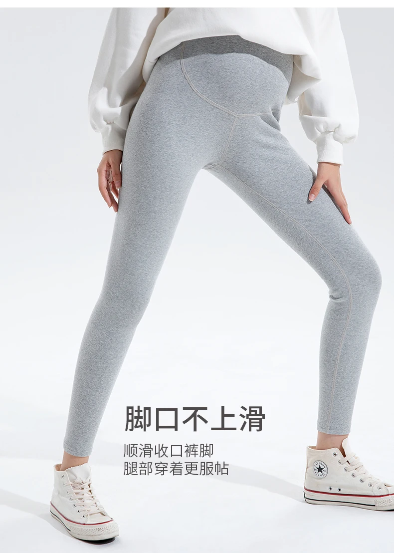 Una mujer con una camisa blanca y pantalones grises