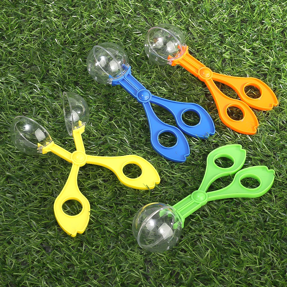 Un grupo de cuatro cucharas de colores diferentes en un campo cubierto de hierba