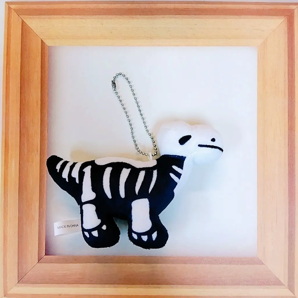 Qualia peluche dinosaurio tipo fósil tiranosaurio con colgante