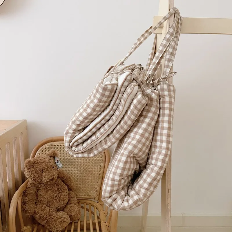 Un oso de peluche marrón sentado en una silla al lado de una bolsa colgante