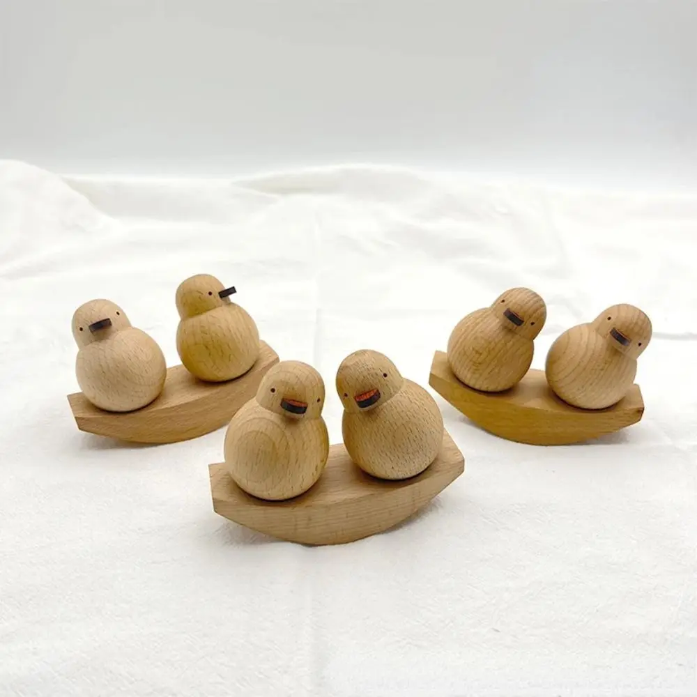 Un grupo de cuatro patos de madera sentados en un bote