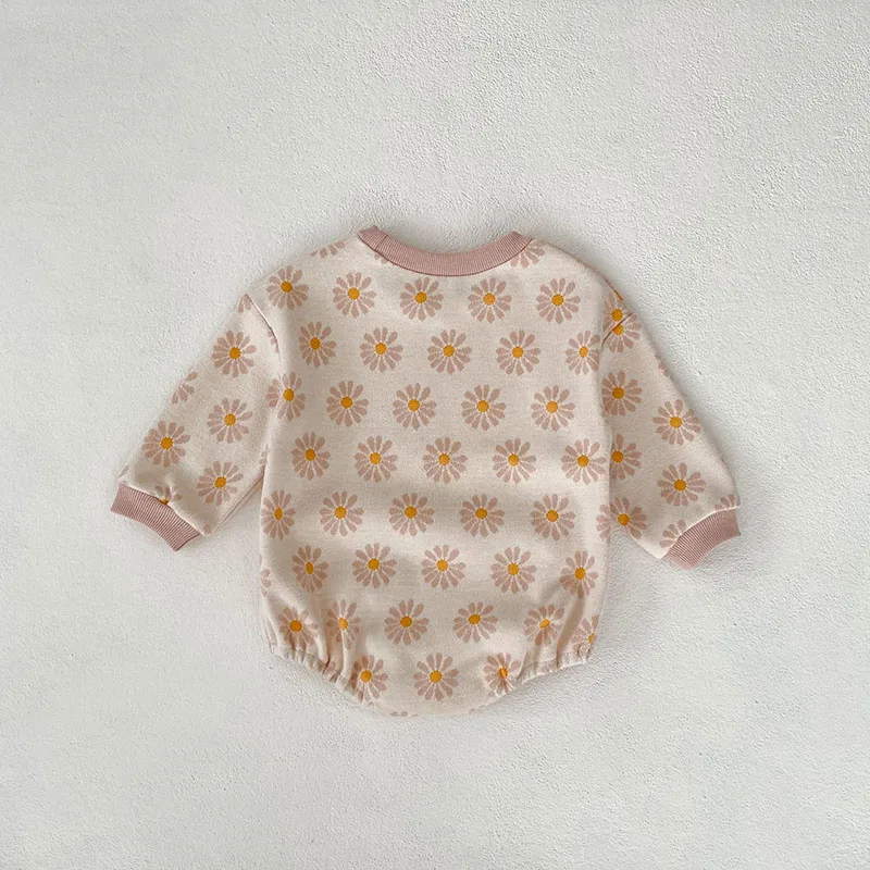 Un suéter de bebé blanco con un patrón de flores